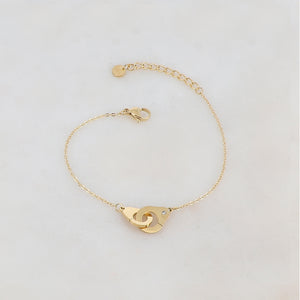 Bracelet doré composé d'une menotte avec un strass blanc